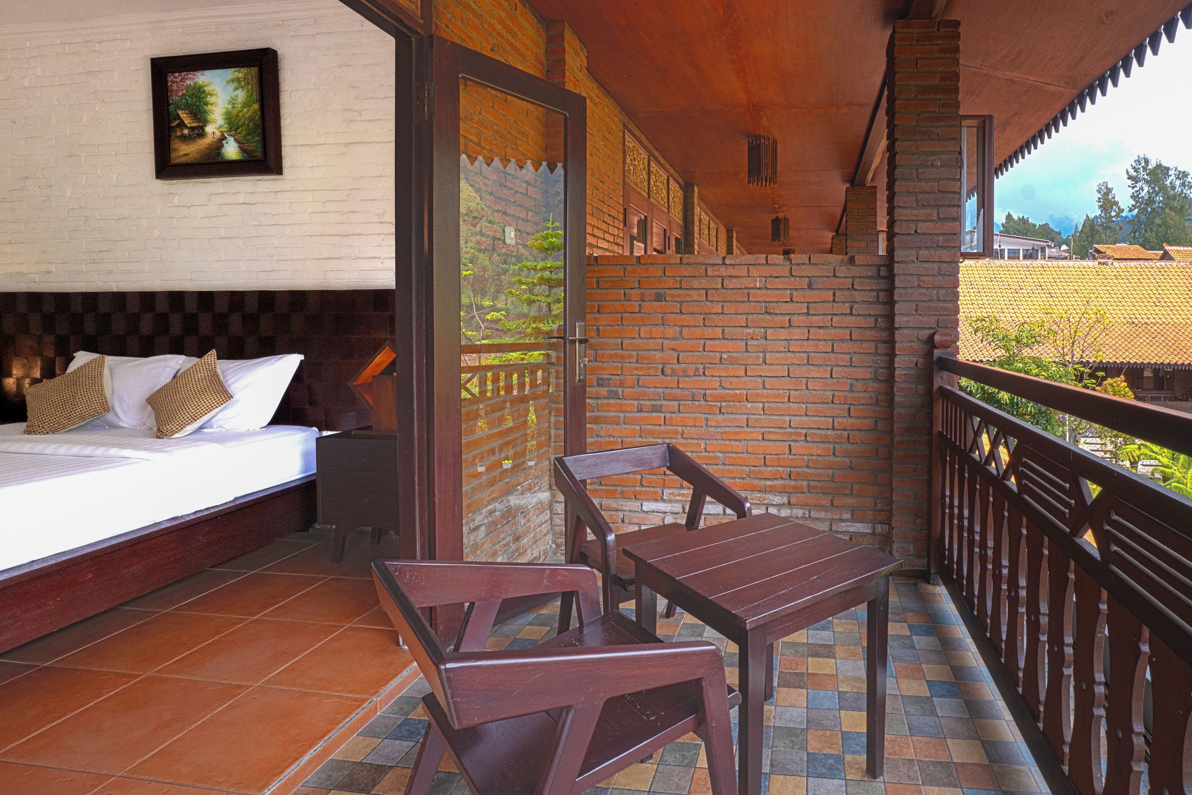 Une chambre avec un lit, une table en bois et un balcon donnant sur les environs.
