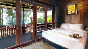 Un dormitorio con una cama grande, vistas a un espacio exterior a través de una puerta corrediza, y un cuadro en la pared.
