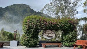Letrero de 'Bawang Bromo Hotel & Rest' con montañas al fondo.