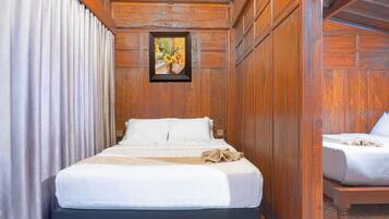 Una habitación con paneles de madera, una cama, un cuadro en la pared y una cortina.