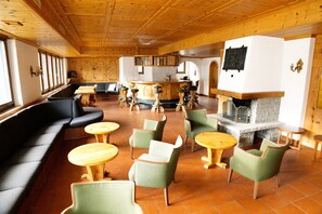 Een restaurant met een houten inrichting, een bar en een open haard.