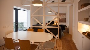Ein modernes Interieur mit Essbereich, einer Couch, einem Fernseher und einem Balkon.