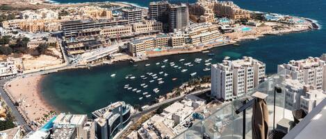 A coastal cityscape with a marina, high-rise buildings, and a beach.