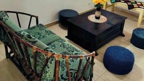 Un soggiorno con divano, tavolino, panca e un quadro appeso al muro.