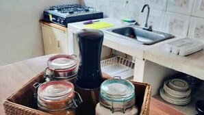 Una cucina con piano di lavoro in legno, lavello, pensili e fornello.