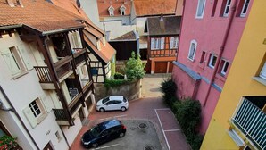 A narrow street with parked cars and buildings on either side. - 2-BEDROOM LOFT WITH PETITE VENISE RIVER VIEW PRIVATE PARKING (Colmar)