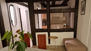 A room with a dining table, chairs, a potted plant, a sofa, and a view into a kitchen. - 2-BEDROOM LOFT WITH PETITE VENISE RIVER VIEW PRIVATE PARKING (Colmar)