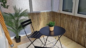 A corner room with a black metal table and bench, a potted plant, and a textured wall. - Holiday Home 'M B Homes Albstadt' with Mountain View, Private Terrace, Wi-Fi & Single Room (Albstadt)