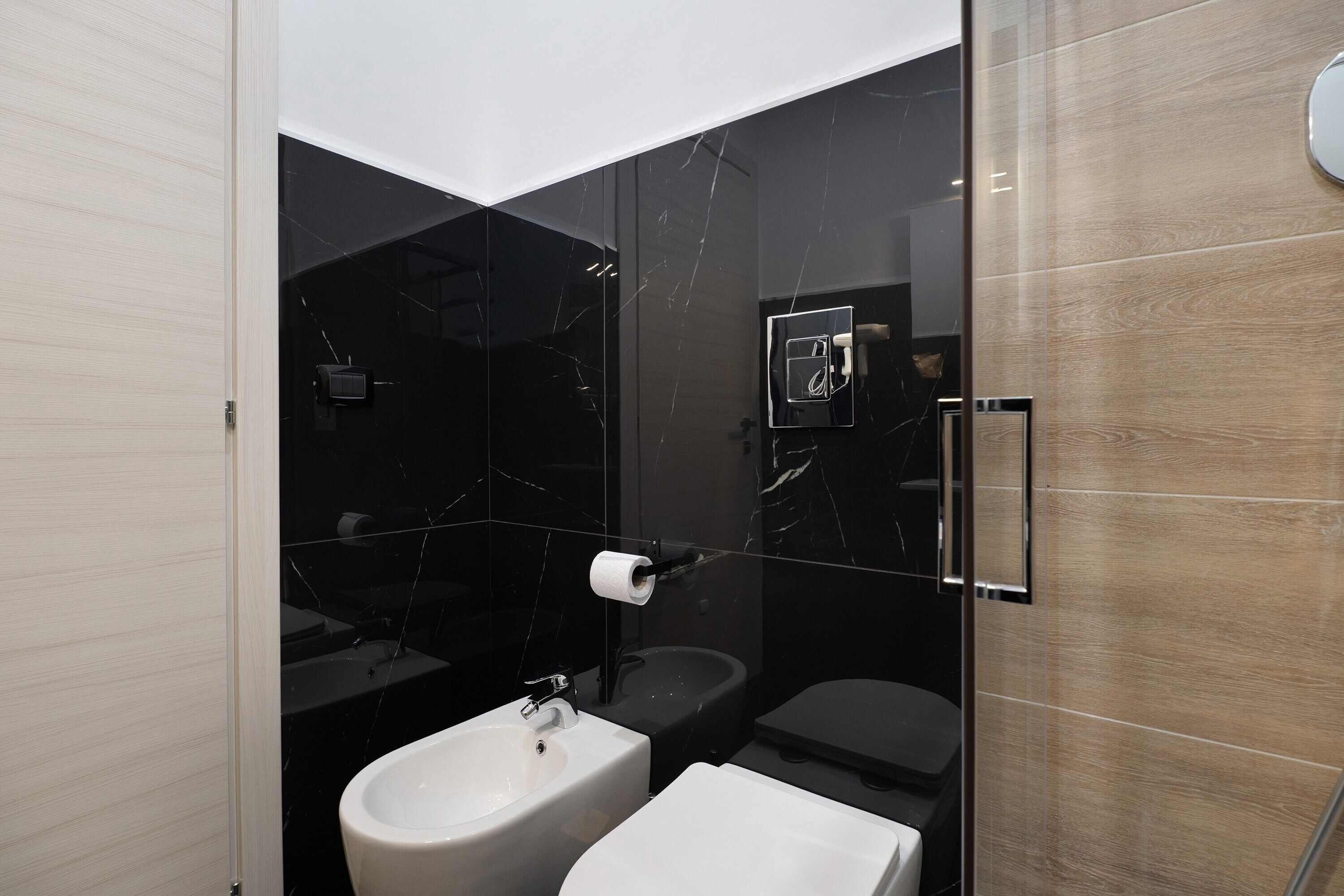 Une salle de bain moderne équipée d’un bidet, de toilettes et d’un lavabo.