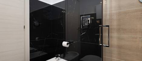 Une salle de bain moderne équipée d’un bidet, de toilettes et d’un lavabo.