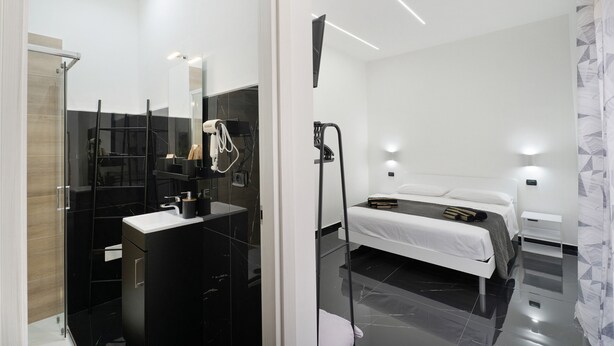 Un dormitorio moderno con cama, mesita de noche y espejo.