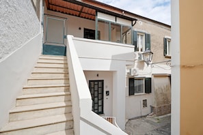 A staircase leading to a second-floor balcony with a view of the street. - Black White Room – Queen Standard (Piazza del Galdo-Sant'angelo)