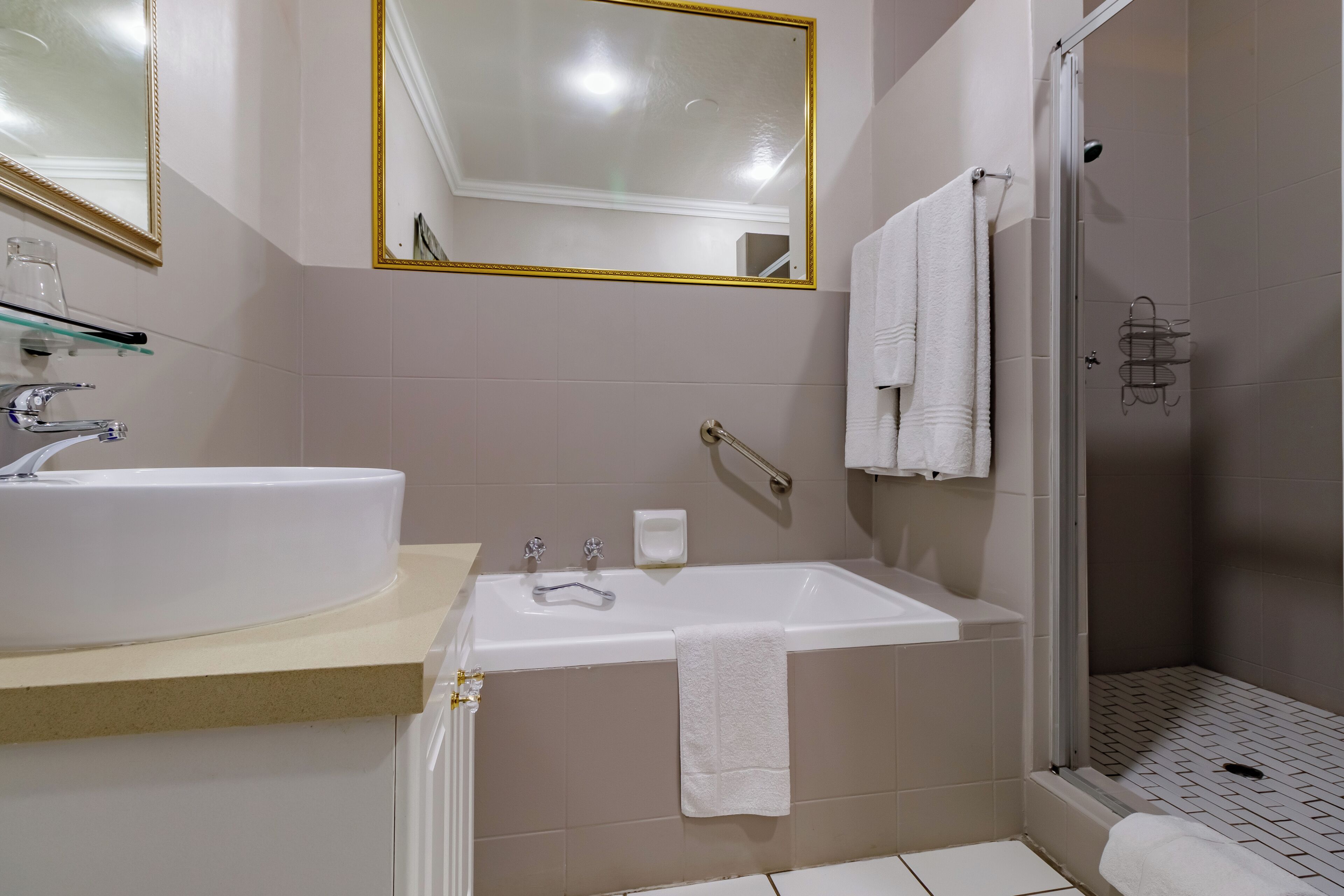 Ein Badezimmer mit Waschbecken, Spiegel, Badewanne und Dusche.
