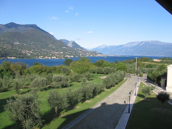 A view of a lake with mountains in the background, a pathway, and greenery. - Il Piccolo Paradiso Holiday Home by Theater Home (San Felice del Benaco)