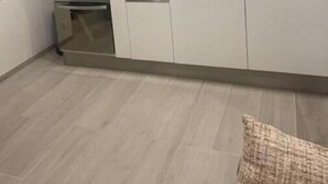 Cozinha moderna com armários brancos, micro-ondas e pia.