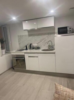 A modern kitchen with white cabinets, a microwave, and a sink. - Lovely Charrons 1 - Large Studio 50 m from the Port, Centre Saint-Tropez (Saint-Tropez)