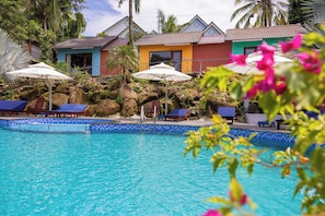 A pool with blue-tiled edges, lounge chairs, and umbrellas. - Solivo Ecolodge Phu Quoc (Phu Quoc)