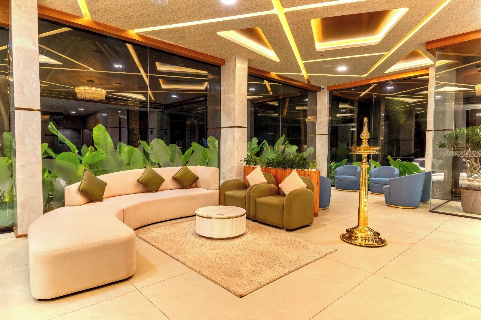 A modern lobby with a curved sofa, a round coffee table, and a decorative golden lamp.