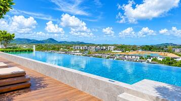 Piscina com vista para uma área residencial e montanhas ao fundo.