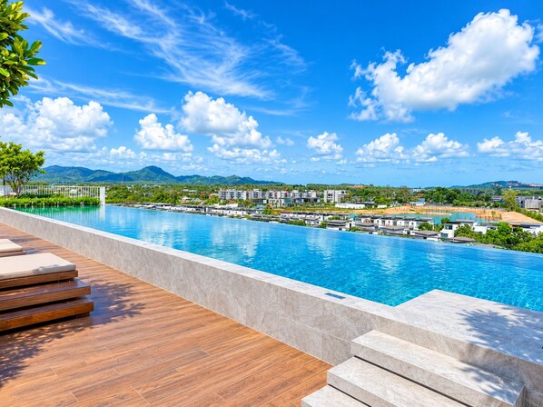 A swimming pool with a view of a residential area and mountains in the background.