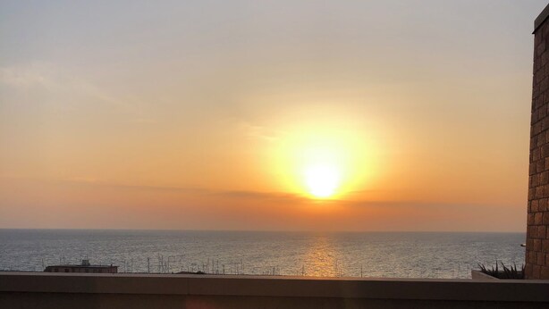 A sunset view from a balcony with a railing and a wall. - Casa Elena - Vista Mare & Parcheggio (San Vincenzo)