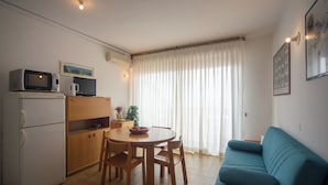 A compact living space with a kitchenette, a dining area, and a sofa. - Casa Elena - Vista Mare & Parcheggio (San Vincenzo)