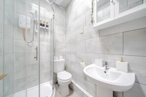 Ein modernes Badezimmer mit einer Duschkabine, einer Toilette und einem Waschbecken.