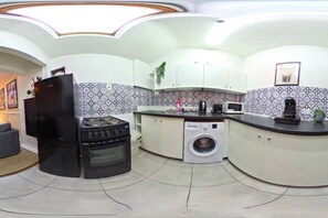 A compact kitchen with a stove, oven, microwave, and washing machine. - One-Bedroom Deluxe Apartment6 City Cent Manchester (Manchester)