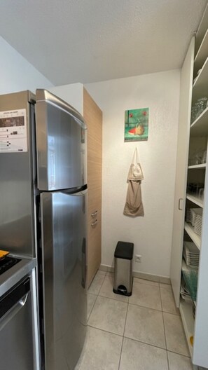 A compact kitchen with a stainless steel refrigerator, a small trash bin, and a wall-mounted towel. - VALBERG TOWN CENTRE - 3 rooms (50m2) 2 bedrooms + 36m2 terrace (VALBERG)