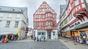 A cobblestone street with traditional half-timbered buildings, a bicycle, and a storefront named 'ENGEL VÖLKERS.'