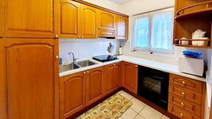 Una cocina con armarios de madera, estufa, fregadero y lavavajillas.