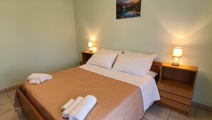 Una habitación de hotel con una cama, dos mesitas de noche y un cuadro colgado en la pared.