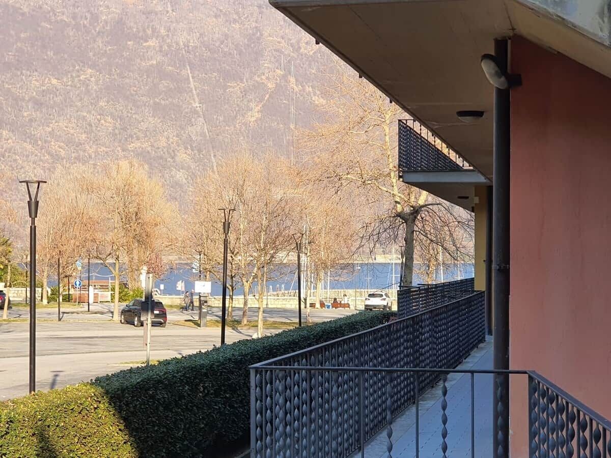 A balcony with a view of a parking lot and mountains.