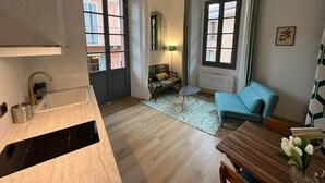 En modern lägenhet med kök, matplats, soffa och ett litet bord.