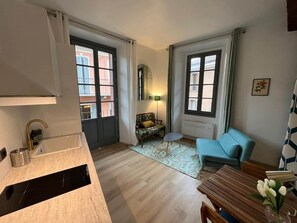 A modern apartment with a kitchen, a dining area, a sofa, and a small table. - Studio Frida Center lake (Intra)