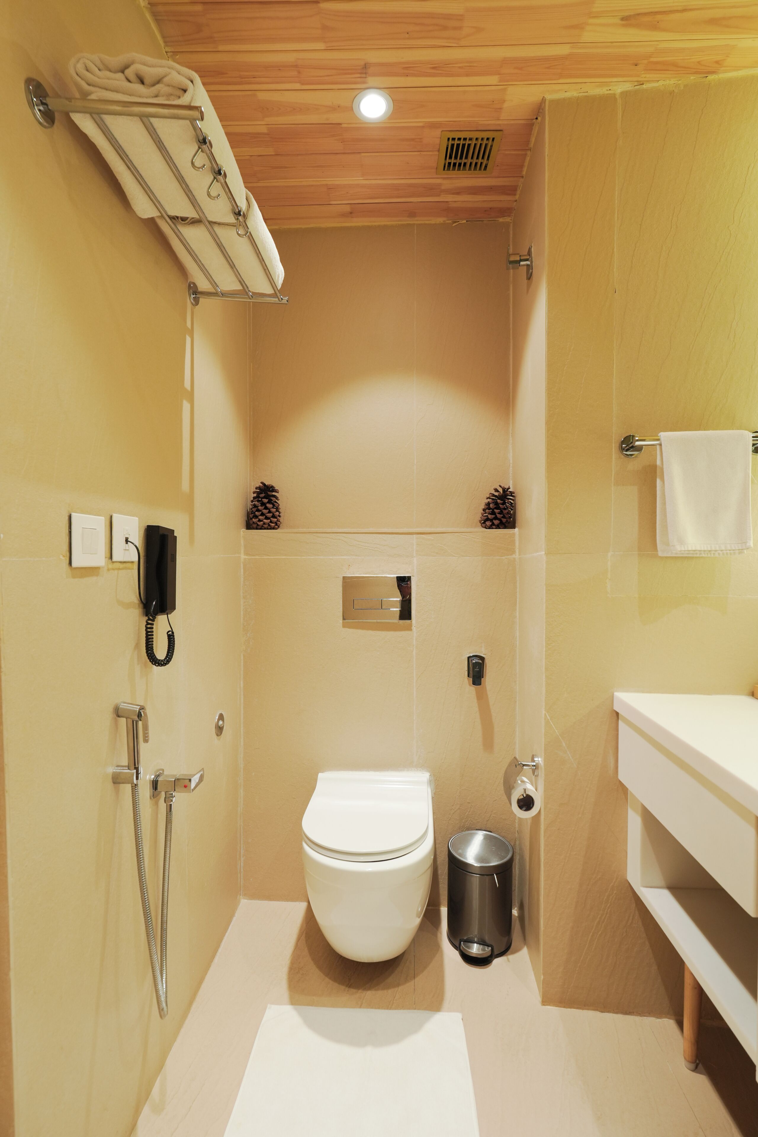 A bathroom with a toilet, shower, and a towel rack.