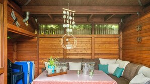 A wooden interior with a table, chairs, and a hanging light fixture.