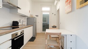 Een kleine keuken met een fornuis, oven en koffiezetapparaat.
