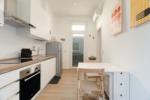 A narrow kitchen with a stove, oven, and coffee maker. - Cozy 40m2 apartment, perfect for 3 people, located on the ground floor of a building.The accommodation is located in Gorla, a historic district of Milan, located in Municipio 2 along Viale Monza, known as the Little Paris for the enchanting atmosphere  (Milan)