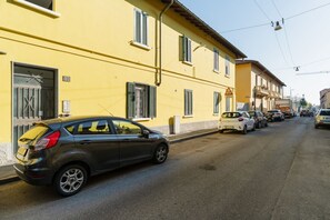 A street with parked cars and a yellow building with shutters. - Cozy 40m2 apartment, perfect for 3 people, located on the ground floor of a building.The accommodation is located in Gorla, a historic district of Milan, located in Municipio 2 along Viale Monza, known as the Little Paris for the enchanting atmosphere  (Milan)