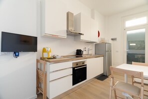 A compact kitchen with a built-in oven, a coffee maker, and a refrigerator. - Cozy 40m2 apartment, perfect for 3 people, located on the ground floor of a building.The accommodation is located in Gorla, a historic district of Milan, located in Municipio 2 along Viale Monza, known as the Little Paris for the enchanting atmosphere  (Milan)