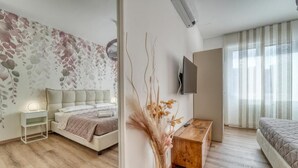 A modern bedroom with a bed, bedside table, and a wall-mounted TV. - Casa Ginevra-Modern Design (Como)