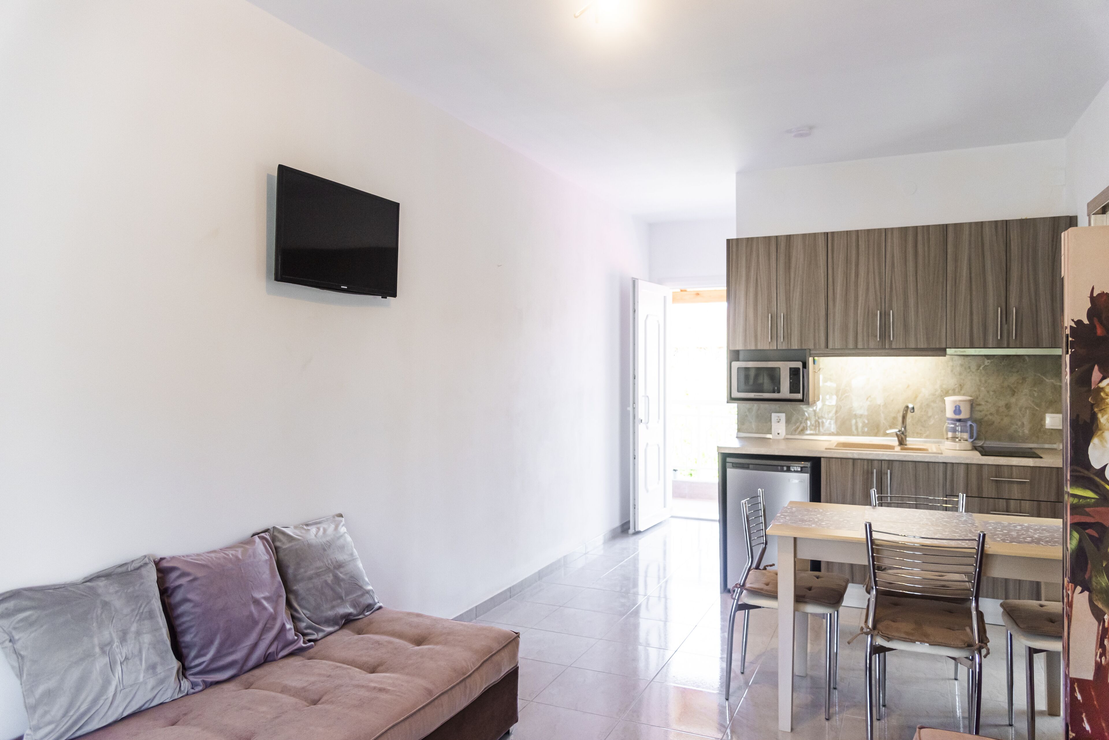 Una sala moderna con un sofá y un televisor de pantalla plana montado en la pared.