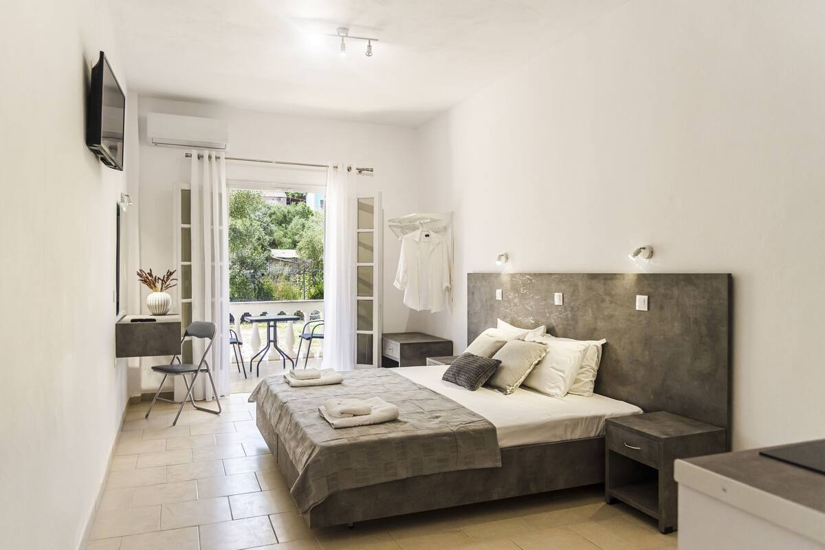 A bedroom with a bed, bedside tables, a desk, and a chair.