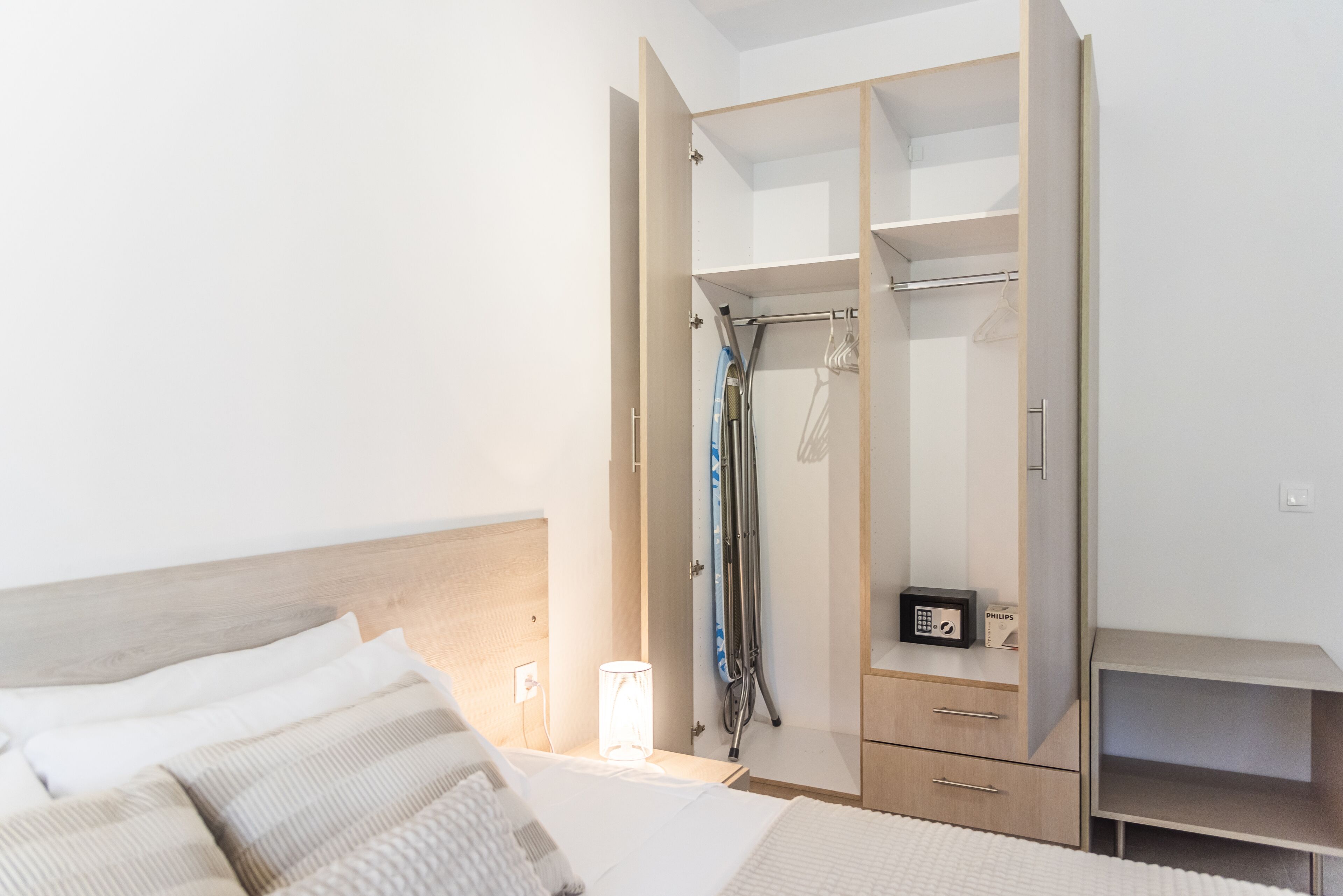 Une chambre à coucher comprenant un lit, une table de chevet, une armoire et une petite table.