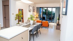 En moderne stue med spiseområde, sofa og udsigt til det fri.