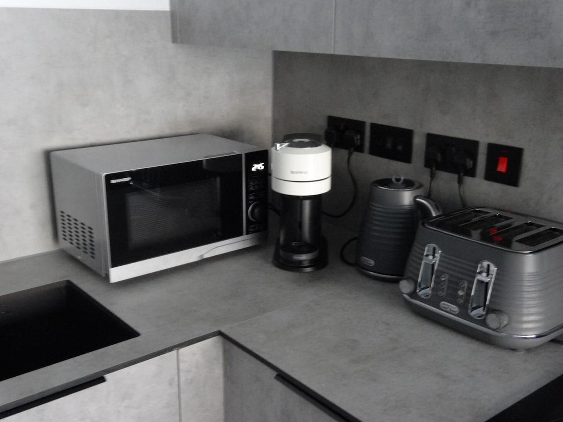 Une petite cuisine équipée d’un four à micro-ondes, d’une machine à café et d’un grille-pain.
