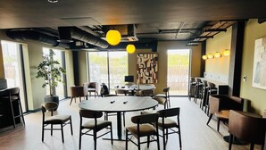 Una sala de reuniones moderna con una mesa redonda, sillas y una planta en maceta.