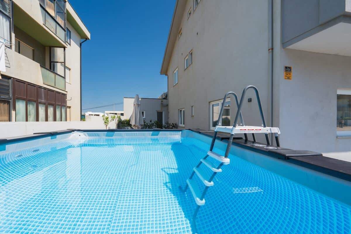 Piscina com escada, cercada por edifícios.