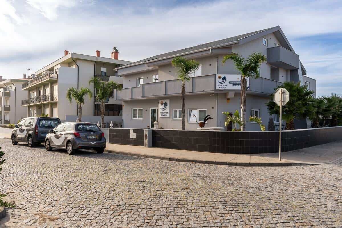 Un hôtel moderne doté d’un toit plat, de nombreux balcons et situé sur une rue pavée.